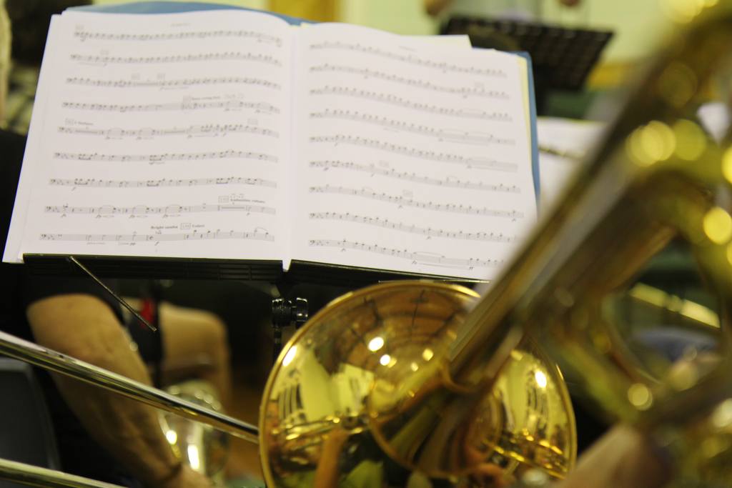 A photo of a trombone and sheet music from a rehearsal.